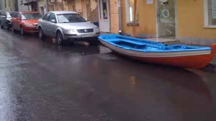 A image of a boat placed in a parking space on a street