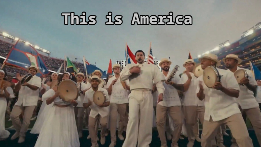 image shows the ending of the Bad Bunny Superbowl Halftime show where he leads a parade of people carrying flags of all the nations of the Americas. Text on the image: "This is America"