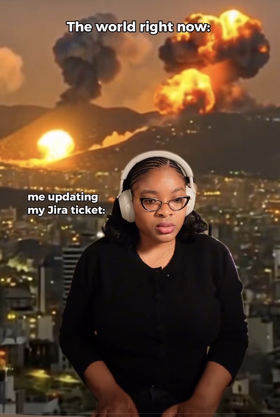 A war scene with explosions and smoke with a woman typing transposed having the caption “The world right now:
me updating my Jira ticket”
